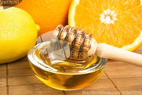 Image of fresh honey with lemon and orange fruits