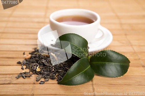 Image of A cup of green tea with freh leaves