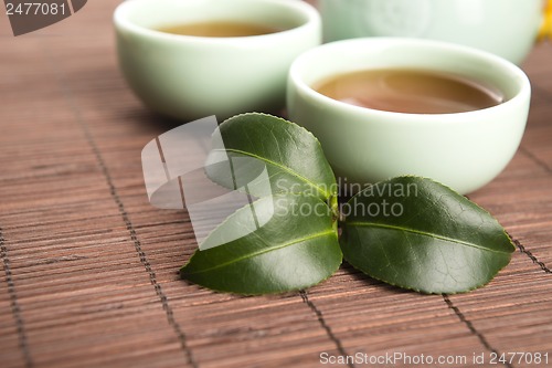 Image of A cup of green tea with freh leaves