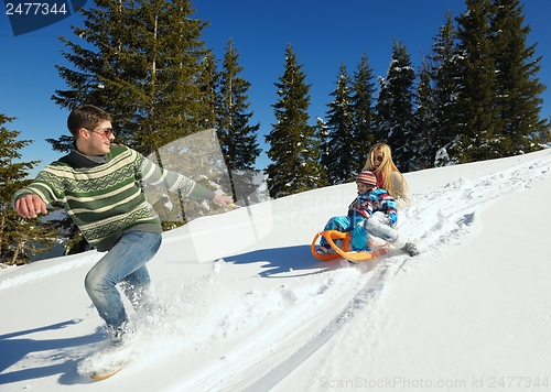 Image of family having fun on fresh snow at winter