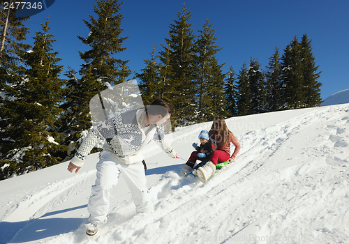 Image of family having fun on fresh snow at winter
