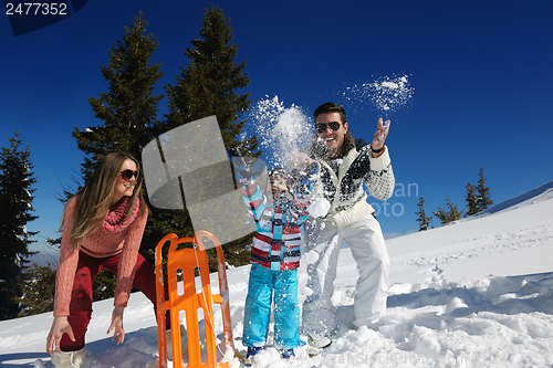 Image of family having fun on fresh snow at winter