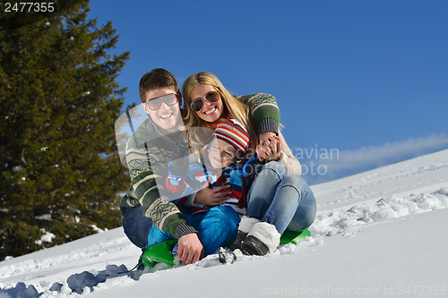 Image of family having fun on fresh snow at winter