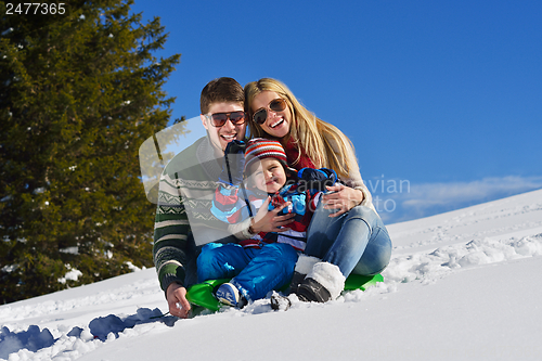 Image of family having fun on fresh snow at winter