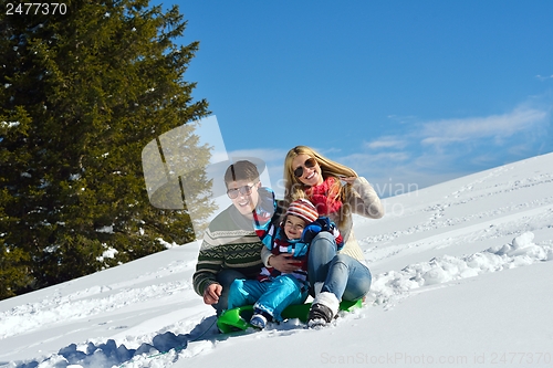 Image of family having fun on fresh snow at winter