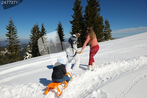 Image of family having fun on fresh snow at winter