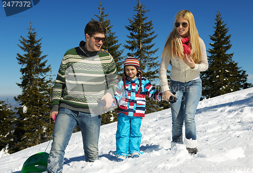 Image of family having fun on fresh snow at winter