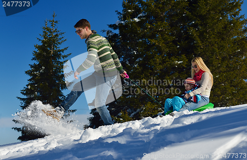 Image of family having fun on fresh snow at winter