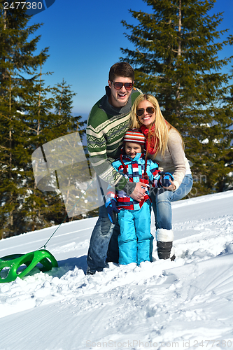 Image of family having fun on fresh snow at winter