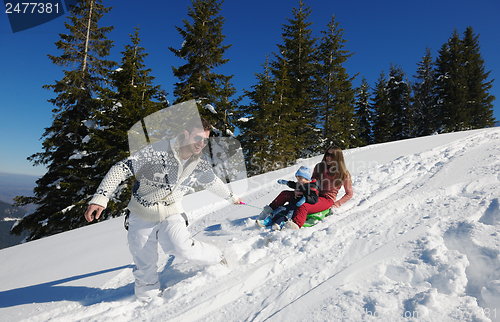 Image of family having fun on fresh snow at winter