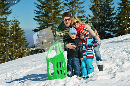 Image of family having fun on fresh snow at winter