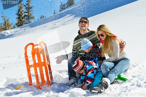 Image of family having fun on fresh snow at winter