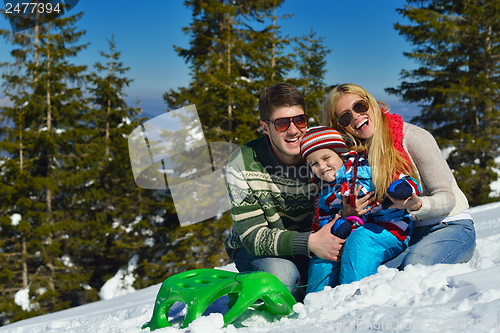 Image of family having fun on fresh snow at winter