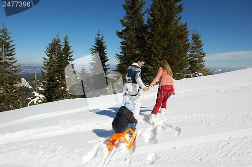 Image of family having fun on fresh snow at winter