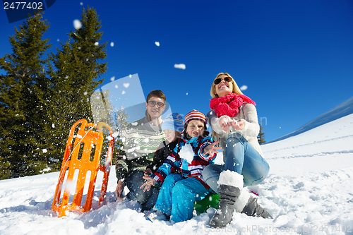 Image of family having fun on fresh snow at winter