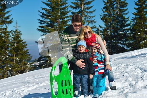 Image of family having fun on fresh snow at winter