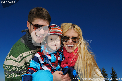 Image of family having fun on fresh snow at winter