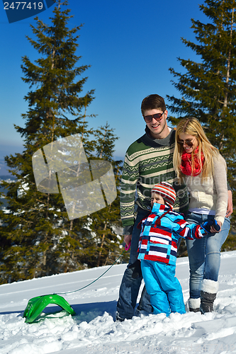 Image of family having fun on fresh snow at winter