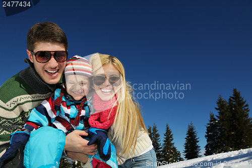 Image of family having fun on fresh snow at winter