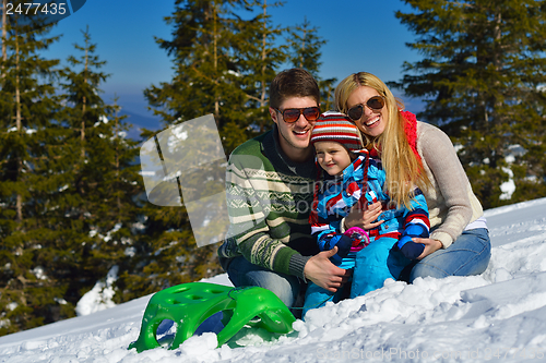 Image of family having fun on fresh snow at winter