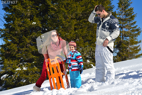 Image of family having fun on fresh snow at winter