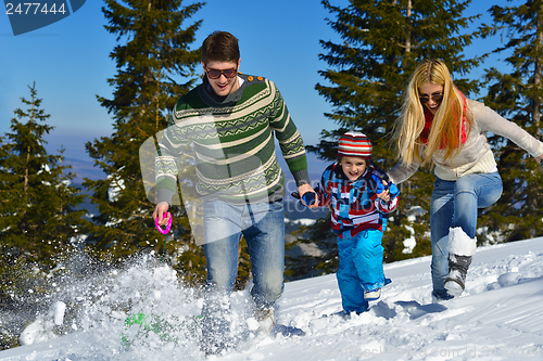 Image of family having fun on fresh snow at winter