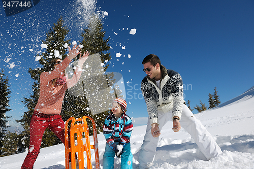 Image of family having fun on fresh snow at winter