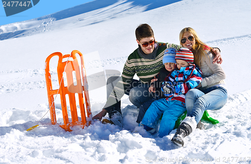 Image of family having fun on fresh snow at winter