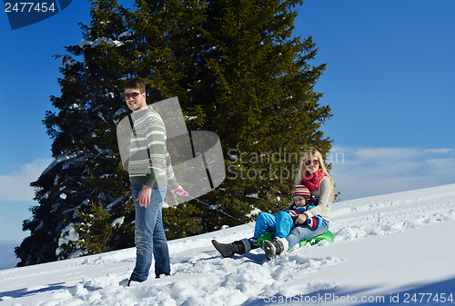 Image of family having fun on fresh snow at winter