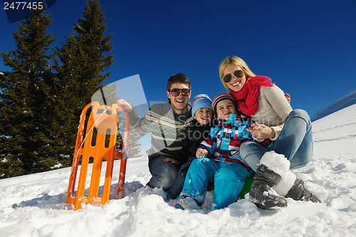 Image of family having fun on fresh snow at winter