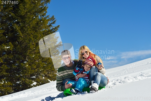 Image of family having fun on fresh snow at winter