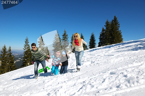 Image of family having fun on fresh snow at winter