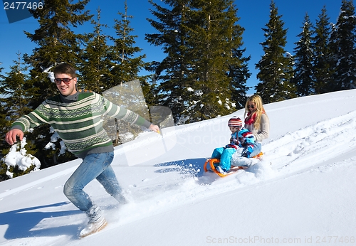 Image of family having fun on fresh snow at winter