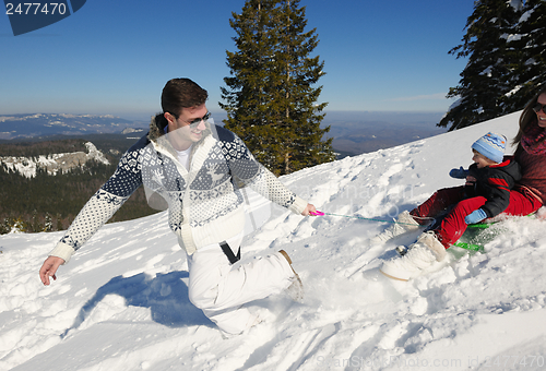 Image of family having fun on fresh snow at winter