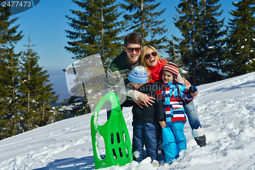 Image of family having fun on fresh snow at winter