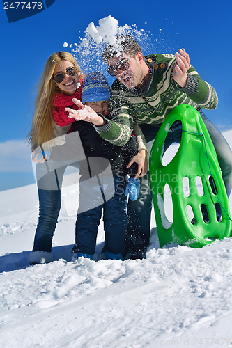 Image of family having fun on fresh snow at winter