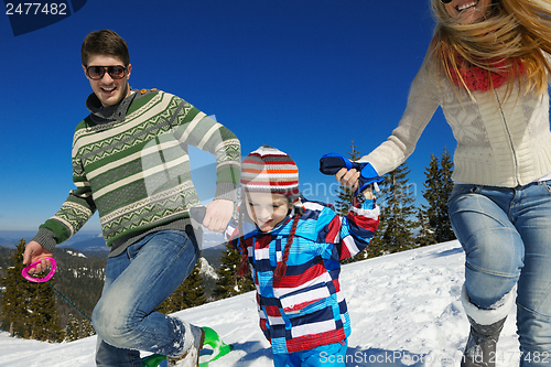 Image of family having fun on fresh snow at winter