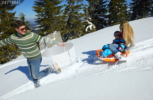 Image of family having fun on fresh snow at winter