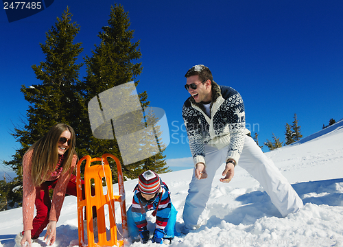 Image of family having fun on fresh snow at winter
