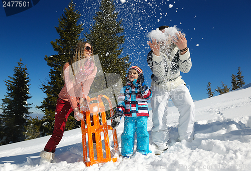 Image of family having fun on fresh snow at winter