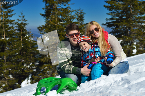Image of family having fun on fresh snow at winter