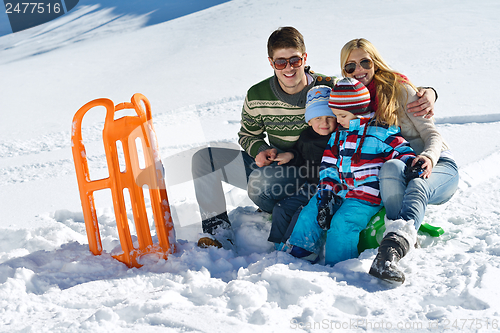 Image of family having fun on fresh snow at winter