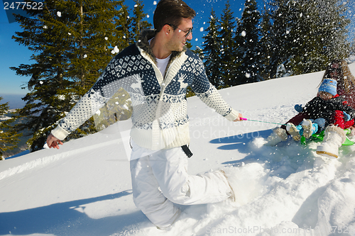 Image of family having fun on fresh snow at winter