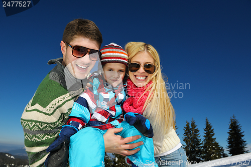 Image of family having fun on fresh snow at winter