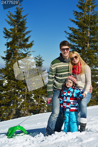Image of family having fun on fresh snow at winter