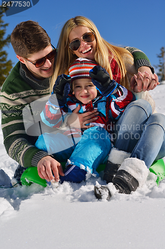 Image of family having fun on fresh snow at winter