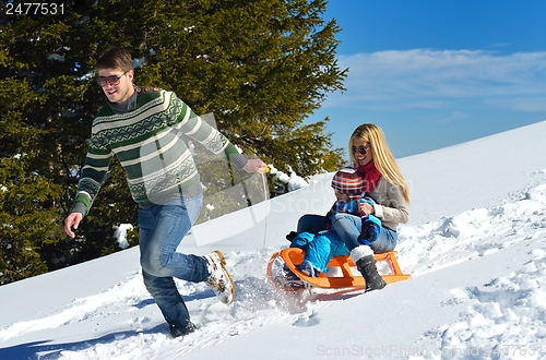 Image of family having fun on fresh snow at winter