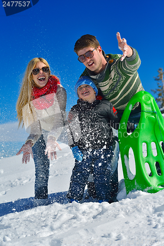 Image of family having fun on fresh snow at winter