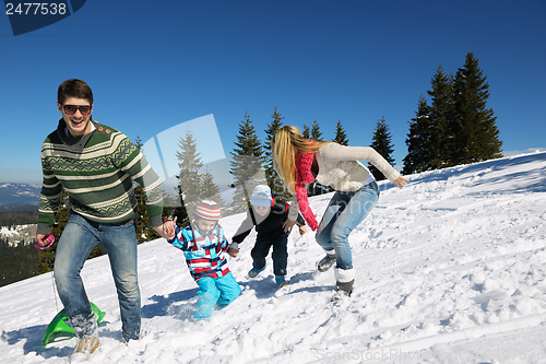 Image of family having fun on fresh snow at winter