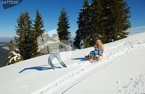 Image of family having fun on fresh snow at winter